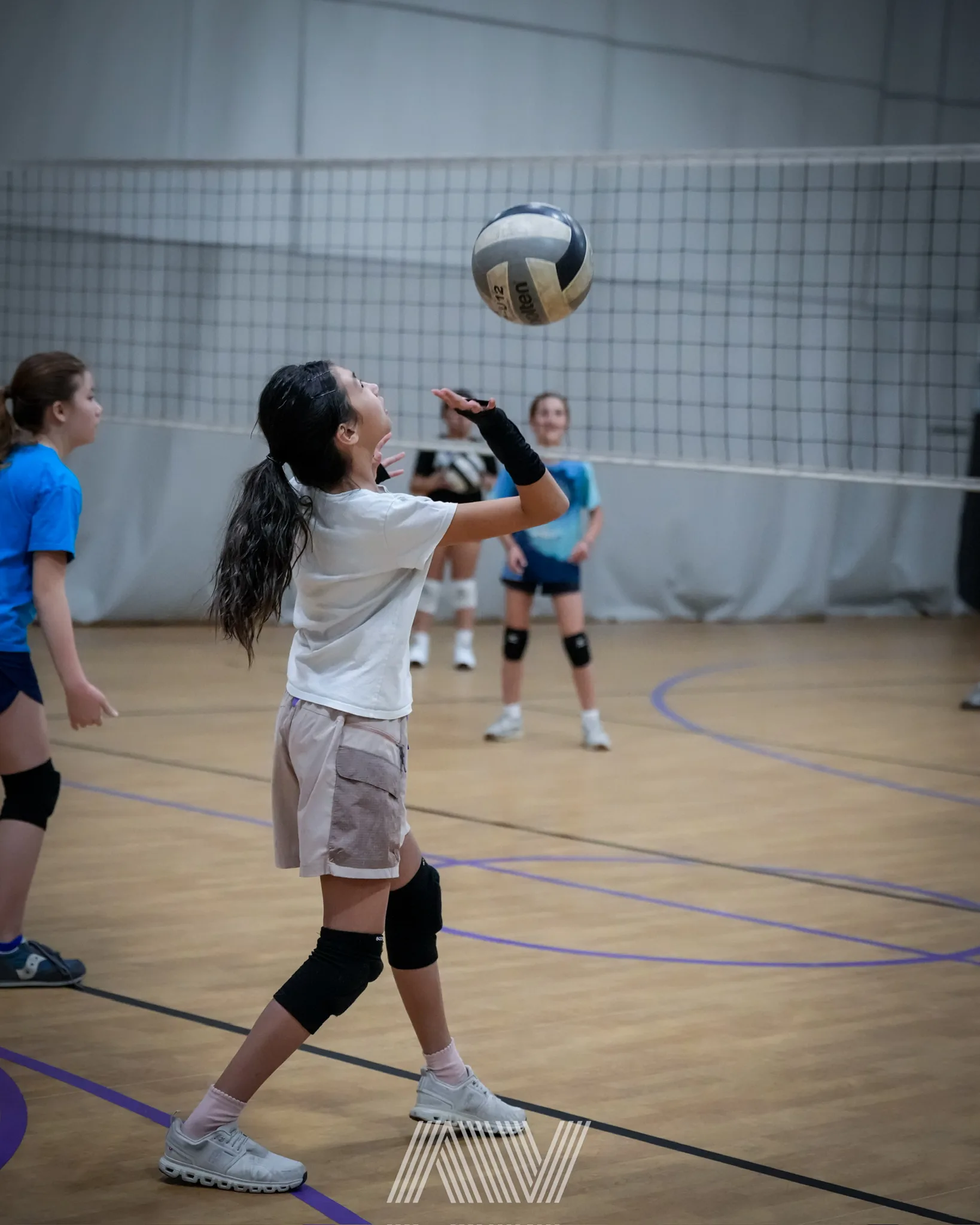 A4 Volleyball player serving inside the training center